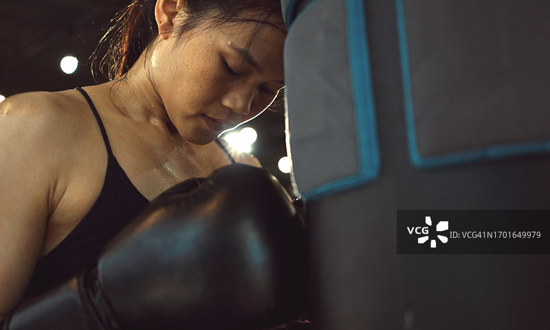拳击后休息的健壮女拳击手。健身房训练日。力量健身身体锻炼图片素材