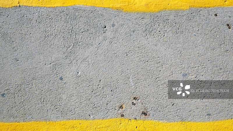 加拿大魁北克蒙特利尔的灰色纹理混凝土墙上的明亮黄色油漆图片素材