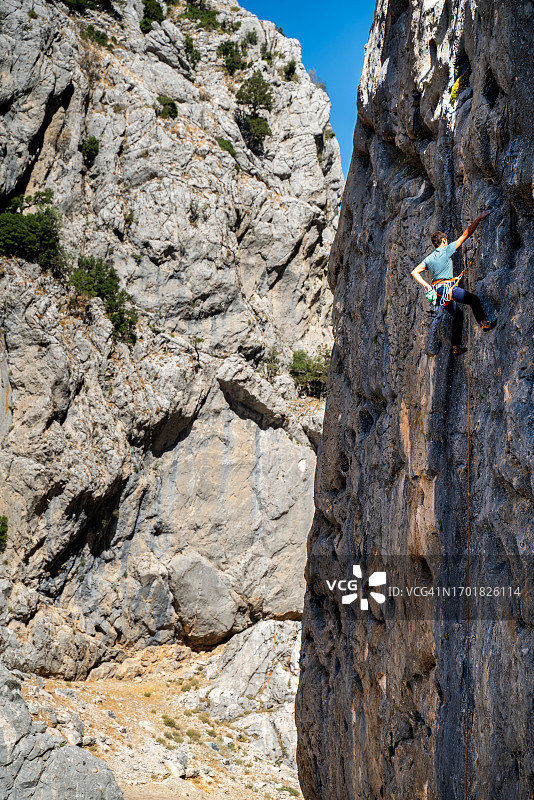 年轻攀岩者在落基山脉攀登危险的墙壁图片素材