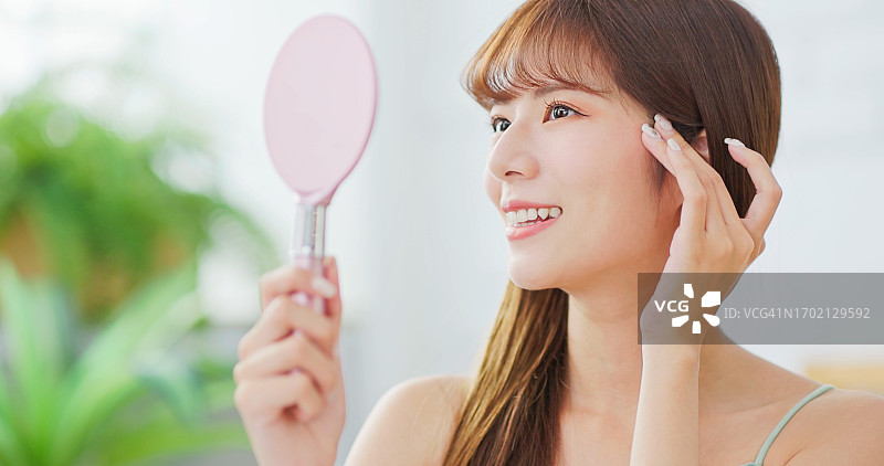 年轻亚洲女子照镜子图片素材
