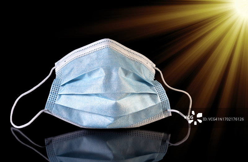 黑色背景上的蓝色医用口罩图片素材