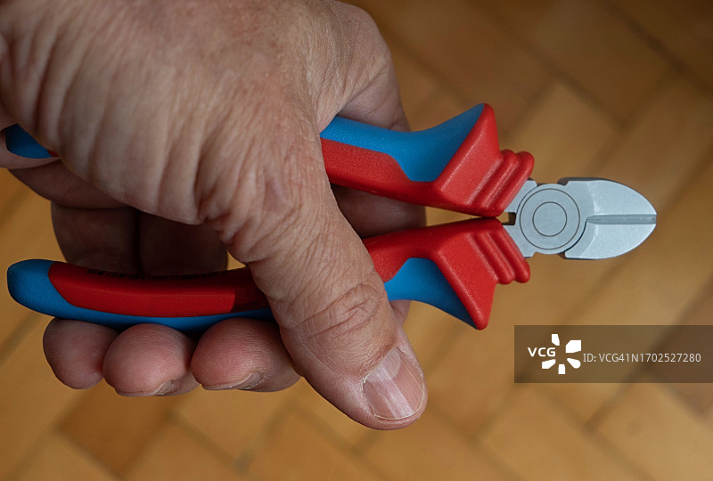 左手握着斜口钳的高角度视图图片素材