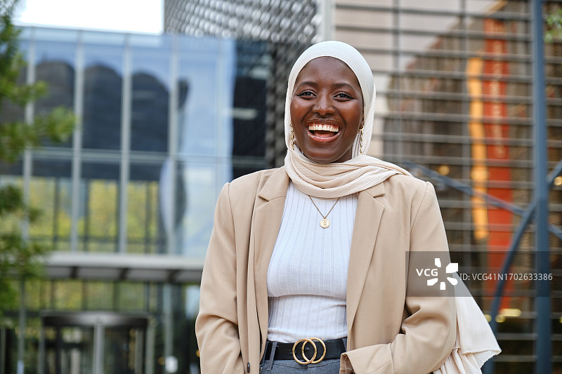 在城市里微笑的优雅非洲穆斯林女商人图片素材
