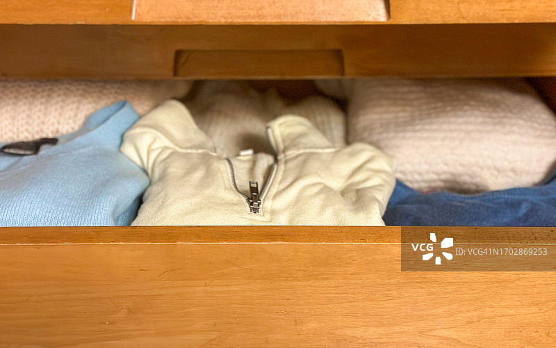 展示折叠衣服的打开的梳妆台抽屉图片素材