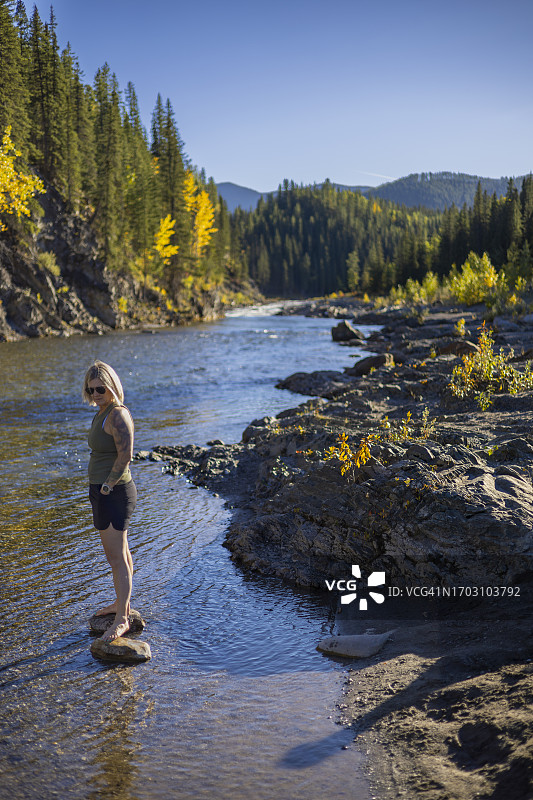 秋日，女人在河畔漫步图片素材
