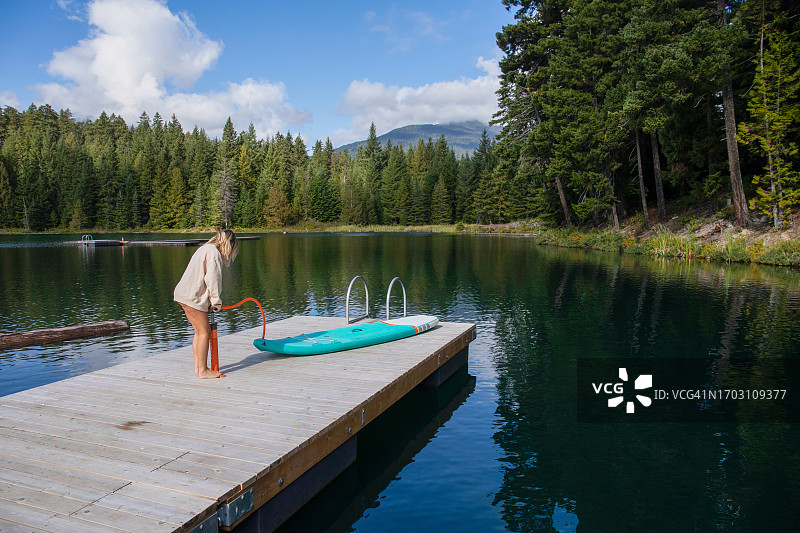 女人正在给站立式桨板充气图片素材
