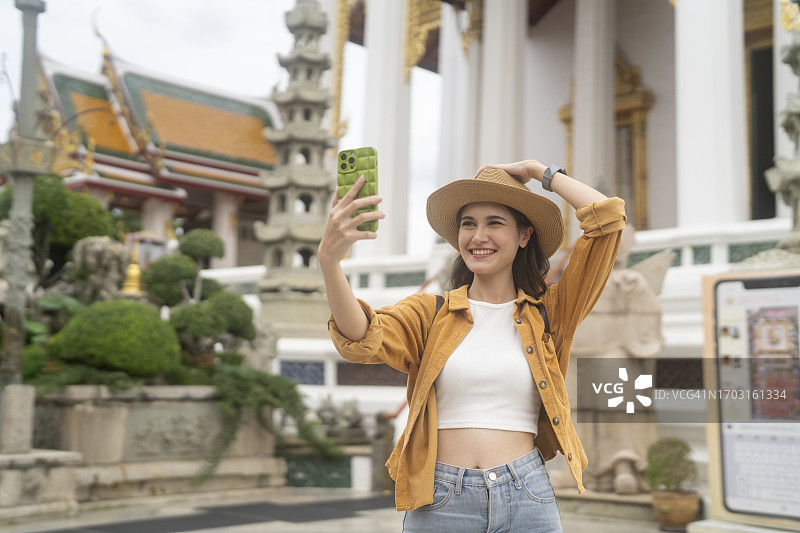 快乐的女博主录制旅行视频博客，自拍，看着镜头图片素材