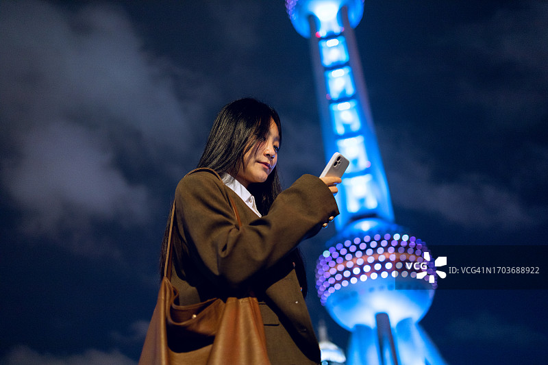 在中国上海东方明珠塔下使用手机的商人图片素材