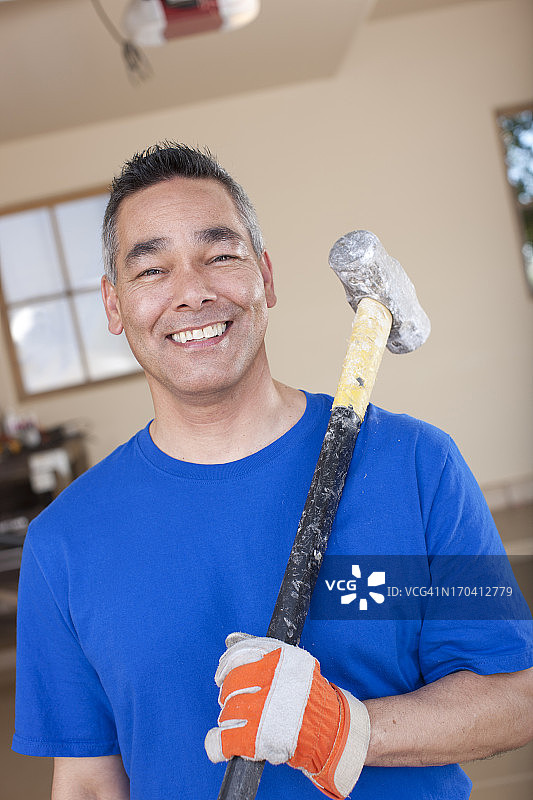 男人在车库里拿着大锤图片素材
