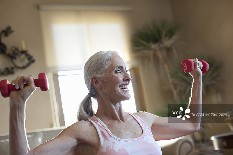老年妇女在家举重图片素材