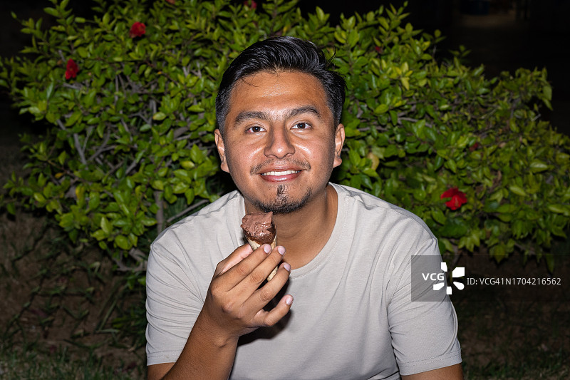 一个晚上拿着冰淇淋微笑的男人图片素材