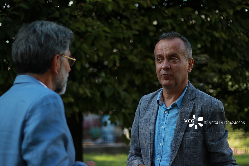 两位表情严肃的年长商人交谈图片素材