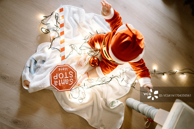 装扮成圣诞老人的男婴在家玩耍图片素材