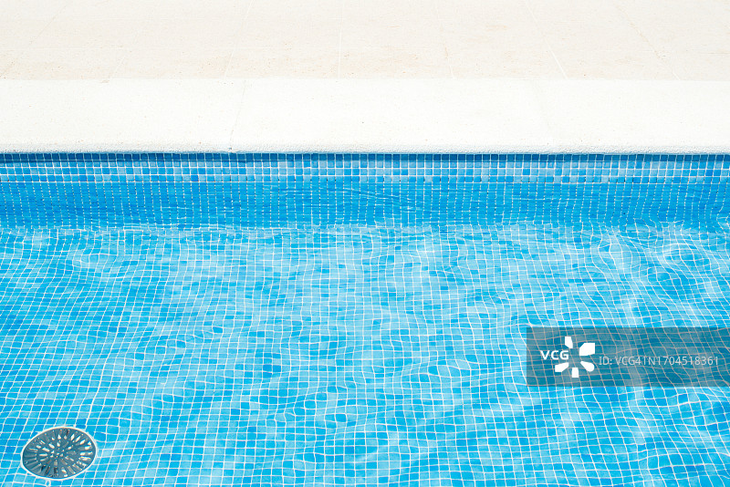 注满蓝色水的游泳池局部图片素材
