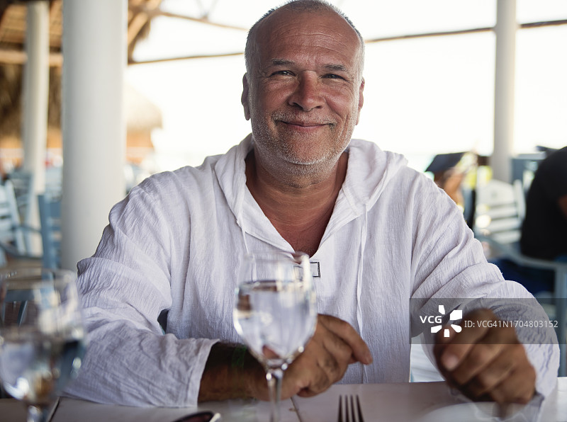 坐在餐厅露台上的一位50多岁的英俊男人肖像图片素材