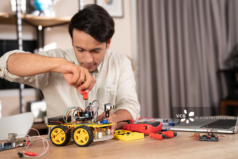 男人的DIY爱好是制造机器人电子线路板图片素材