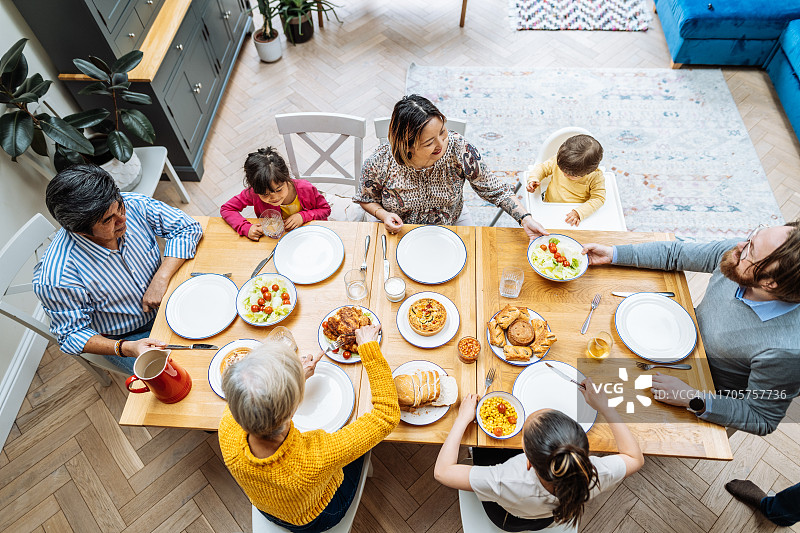 亚裔多代同堂家庭在家中一起享用午餐，高角度拍摄图片素材