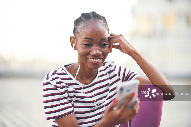 听音乐看手机的年轻微笑女性图片素材