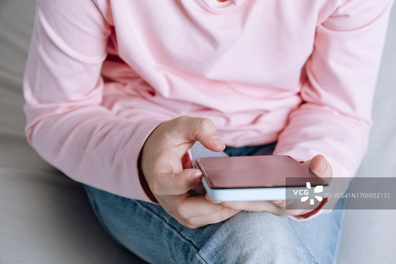 孩子在床上用手机刷社交媒体图片素材