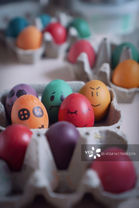 纸质鸡蛋盒中带有绘画表情的彩色复活节彩蛋图片素材