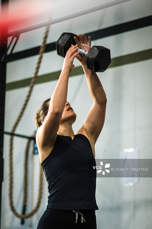 年轻女人在德国健身房用杠铃锻炼图片素材