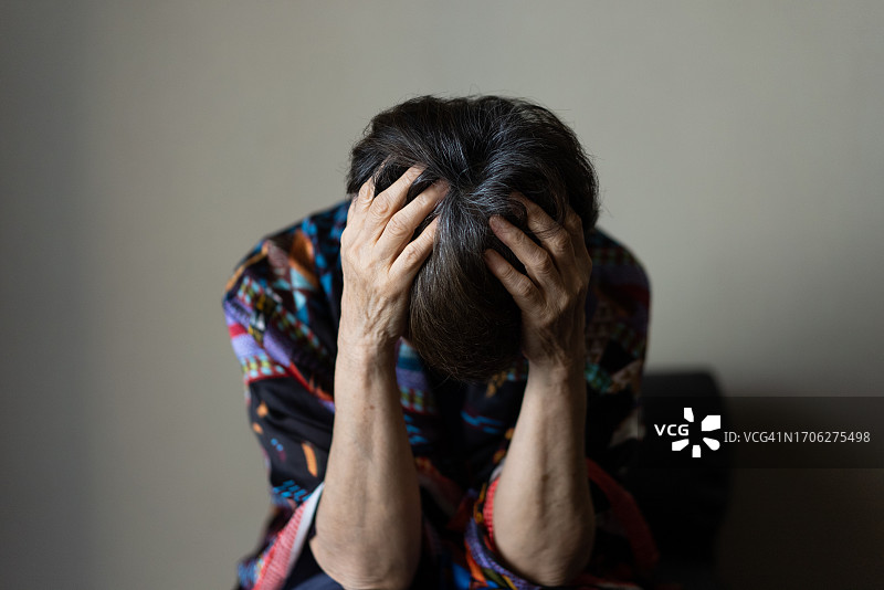 双手抱头瘫倒的老年妇女图片素材