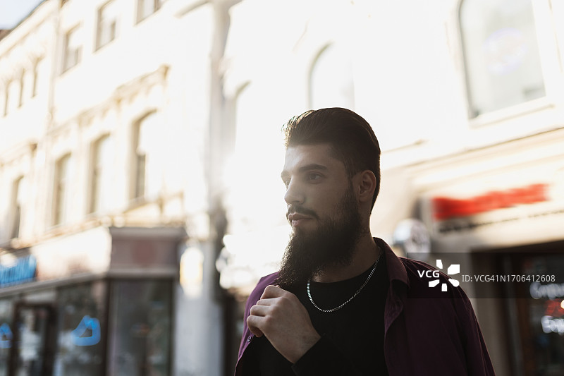 阳光明媚的日子里，站在街上散发着都市气息的时尚男士图片素材
