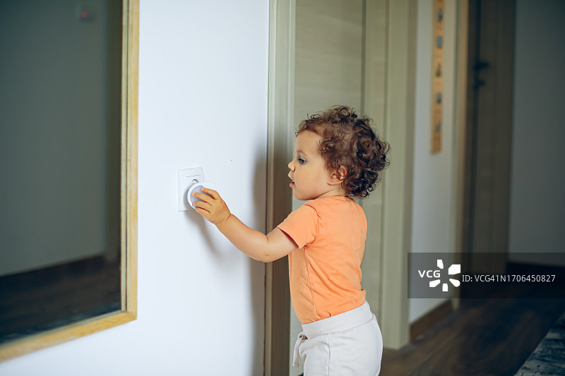 婴儿手触碰墙壁插座图片素材