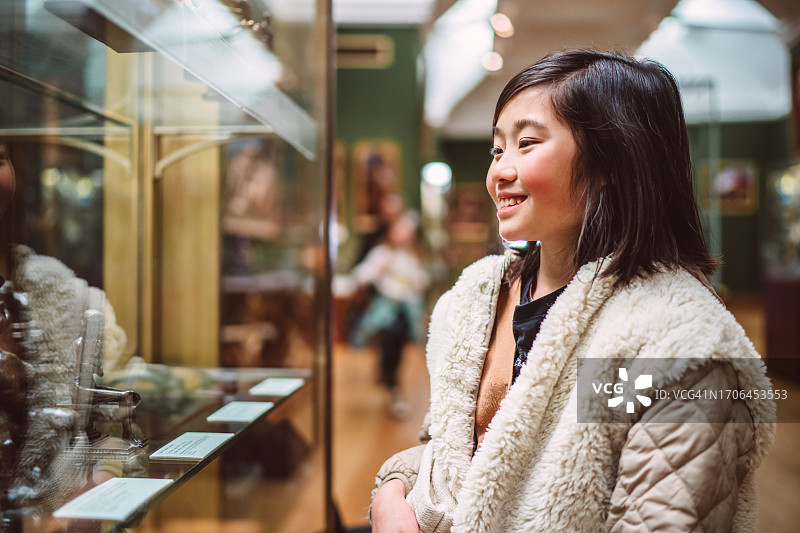 在公共博物馆参观展览的快乐少女图片素材