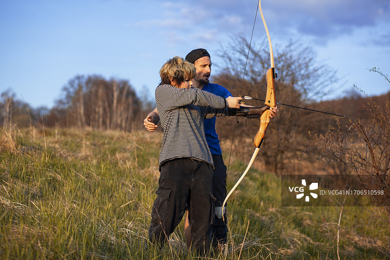 保加利亚的年轻人和年长男人在教射箭图片素材