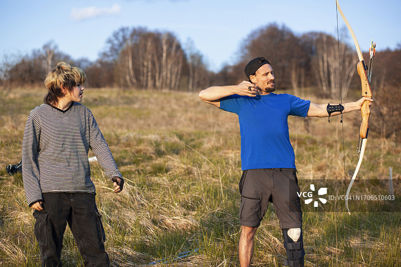 保加利亚的年轻人和年长男人在教射箭图片素材