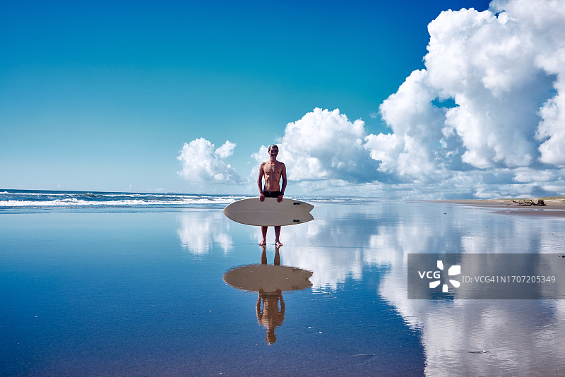 冲浪者站在碧绿海滩上的肖像图片素材