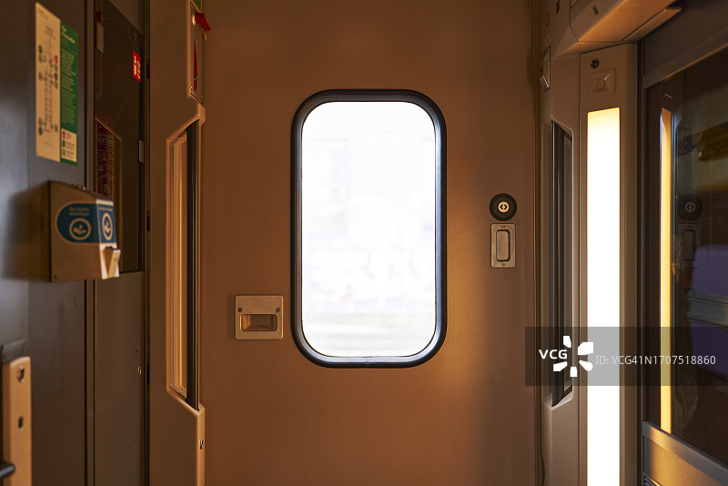 火车内部，一扇带窗户的关闭的门正面图，周围没有人图片素材