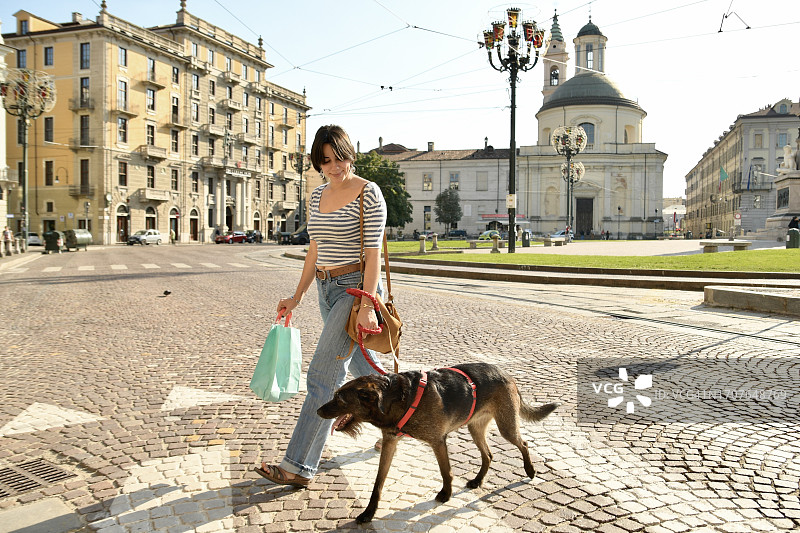 女孩和狗穿过大街图片素材