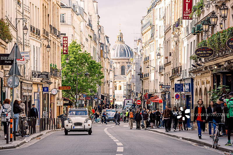 阳光明媚的法国巴黎拉丁区，遍布咖啡馆和餐馆的拥挤街道图片素材