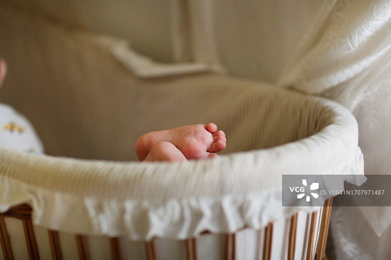 婴儿在摇篮里休息，露出小脚和脚后跟的细节图片素材