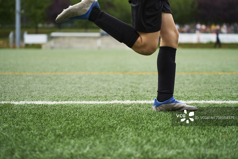 男孩穿着运动服在足球场上跑步的腿部侧视图图片素材