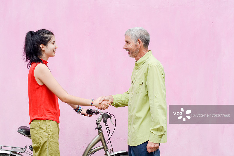 骑自行车向邻居问好的女孩图片素材