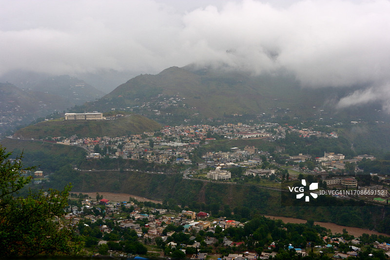 群山环绕的河边城市上空的云彩图片素材