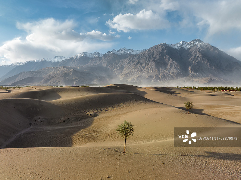 巴基斯坦北部斯卡杜喀喇昆仑山脉卡特帕纳冷沙漠沙丘的无人机日落景观图片素材