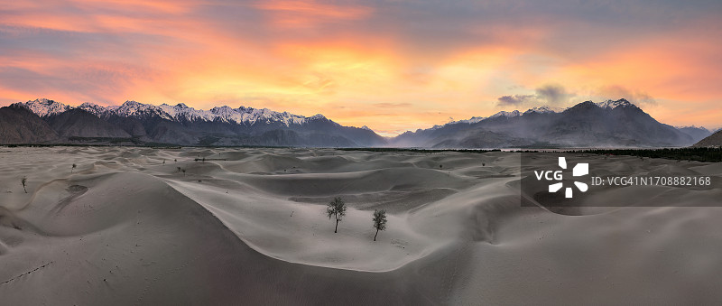 巴基斯坦北部斯卡杜喀喇昆仑山脉卡特帕纳冷沙漠沙丘的无人机日落景观图片素材