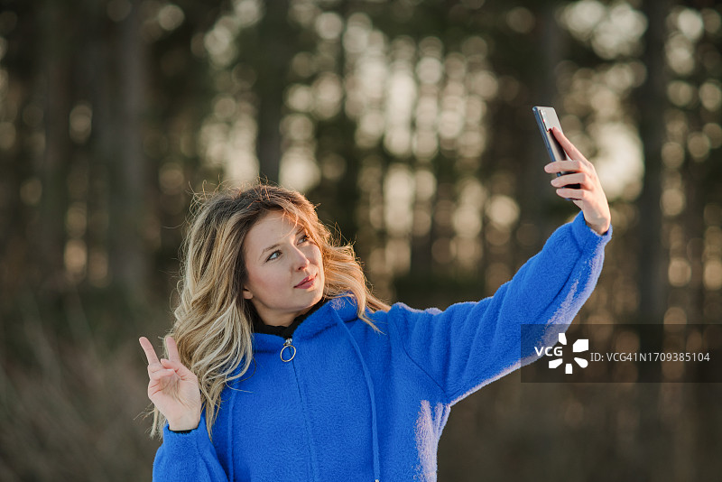 微笑的女人在森林里自拍图片素材