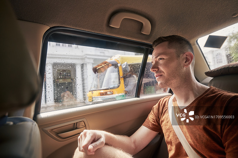 男人乘坐出租车时看向窗外图片素材