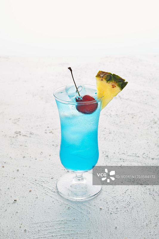 蓝色的冰镇鸡尾酒，配樱桃和菠萝片图片素材