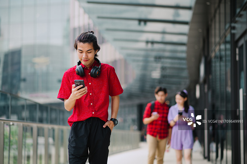在城市中使用设备的亚洲中国女学生图片素材
