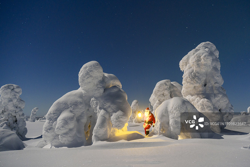 在雪林中提灯探索的圣诞老人图片素材