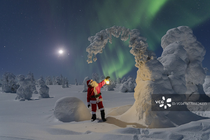 圣诞老人在北极光下欣赏冰雕图片素材