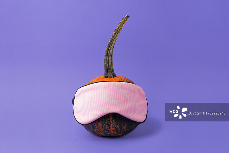 戴着睡眠眼罩的可爱南瓜，昼夜节律和健康睡眠的概念图片素材