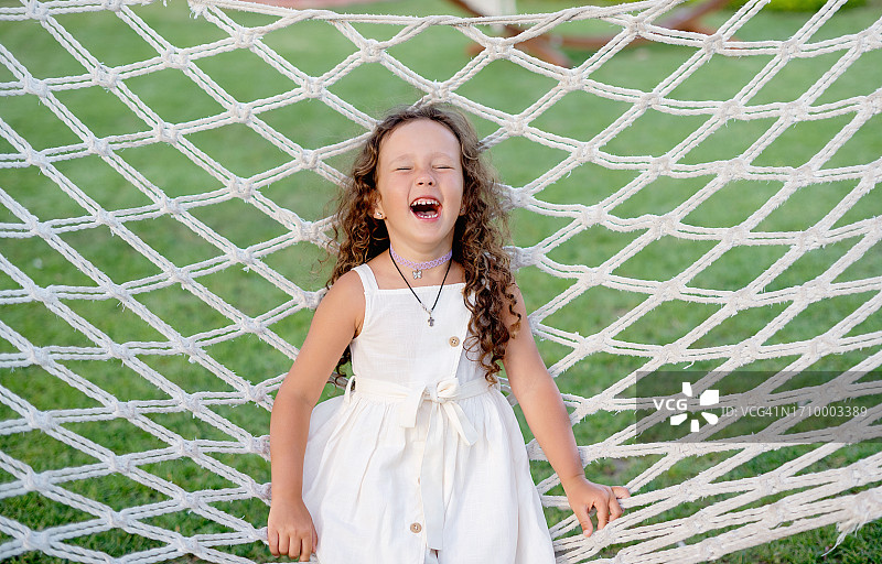 在吊床上荡秋千，享受乡村假期的快乐女孩图片素材