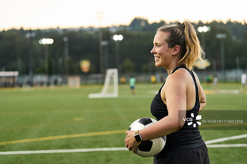 在户外运动场练习的快乐年轻女足球运动员图片素材